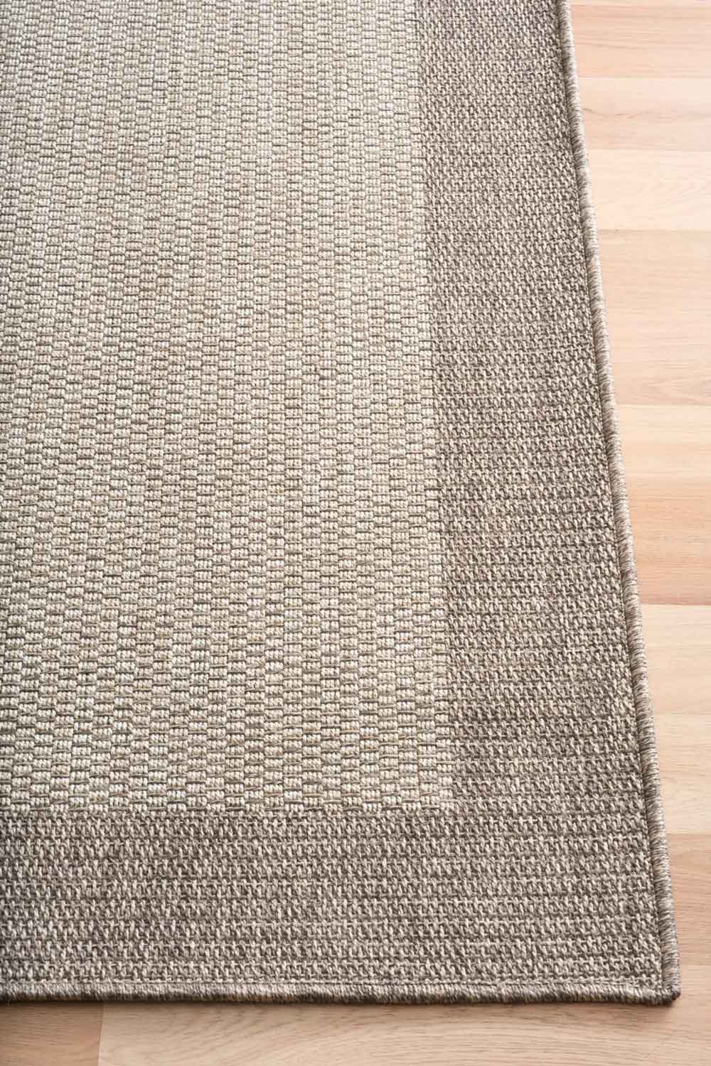 Linden Border Stone indoor outdoor rug with a neutral centre and warm taupe-grey border.  Available at Rugs N Timber Belrose