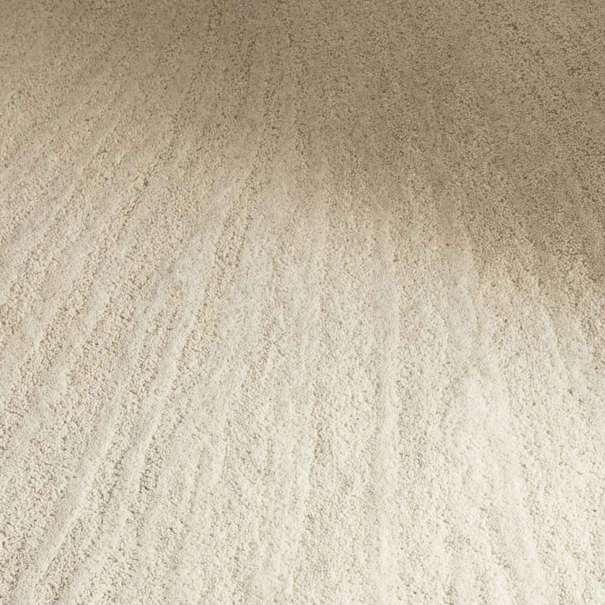 Solace Ivory wool rug with subtle radiating pattern in soft neutral tones