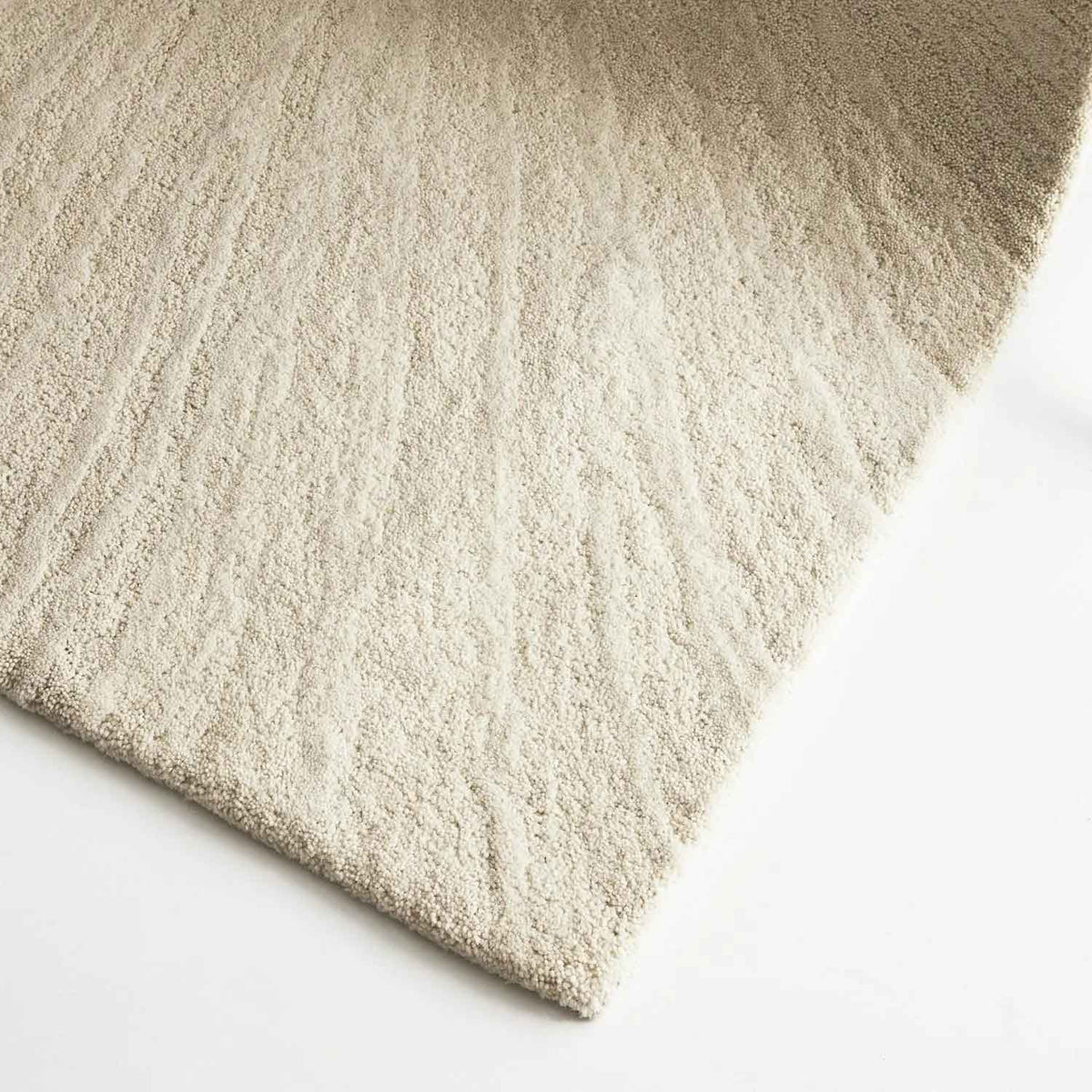 Solace Ivory wool rug with subtle radiating pattern in soft neutral tones