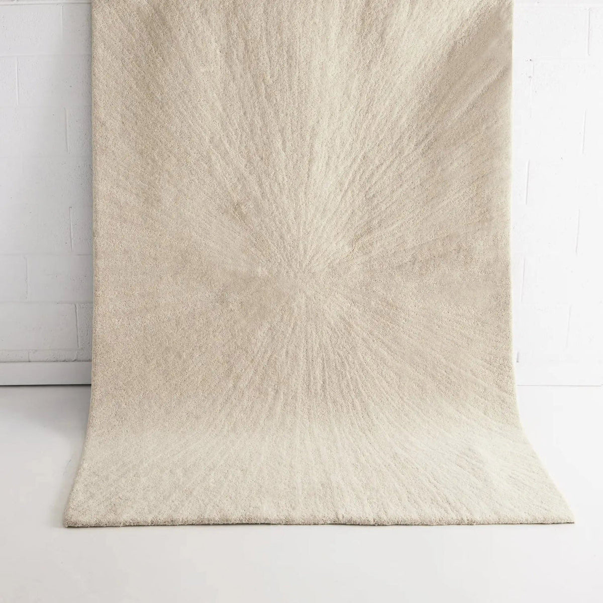Solace Ivory wool rug with subtle radiating pattern in soft neutral tones